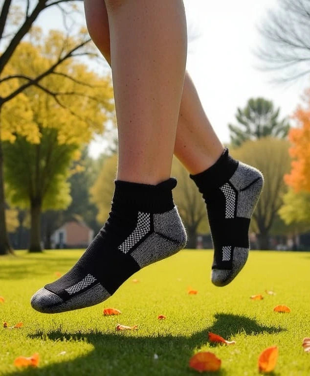 Person jumping for joy, wearing their new Athletic Ankle Alpaca Socks, on a Fall Day, college campus greenspace